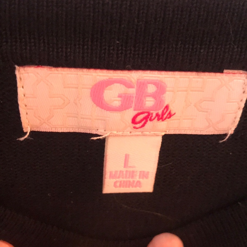A GB black top with white accents on the ruffles